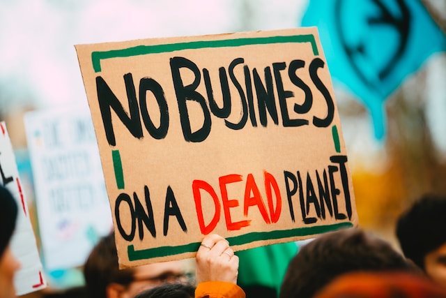 Hand holding up a cardboard sign at a climate change protest