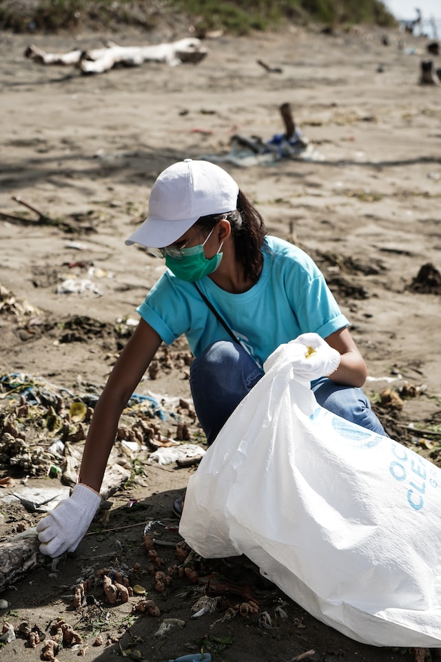 Young girl picking up trash on the shore