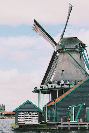 A traditional wind mill beside a lake