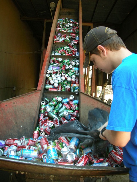 A young man sorting empty soda bottles for recycling